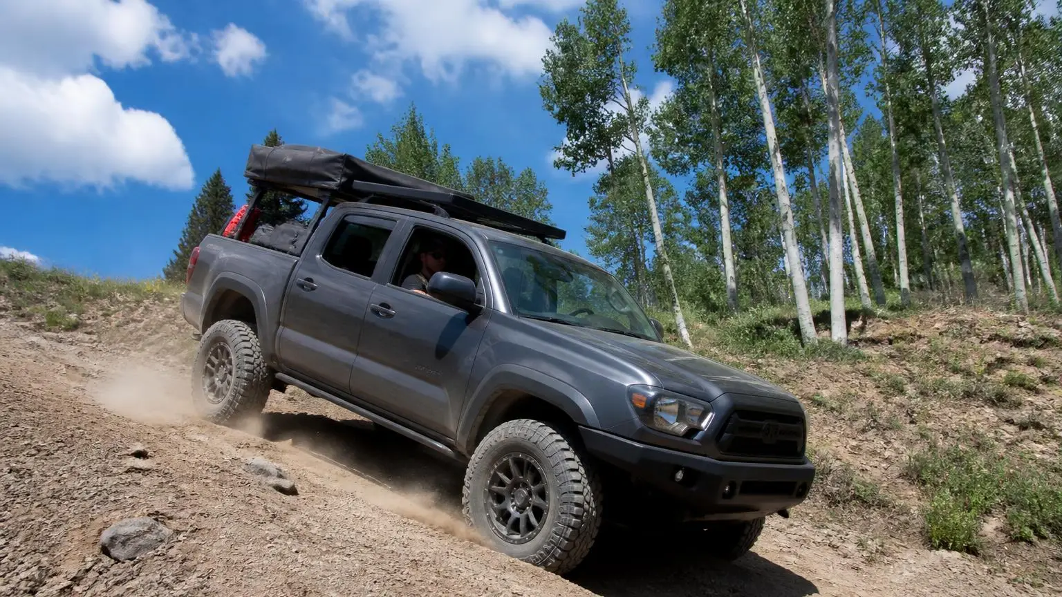 Truck on big tires climbing a steep dirt hill