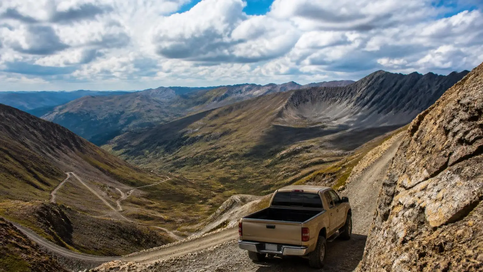 A 4WD descending a steep mountain switchback slowly
