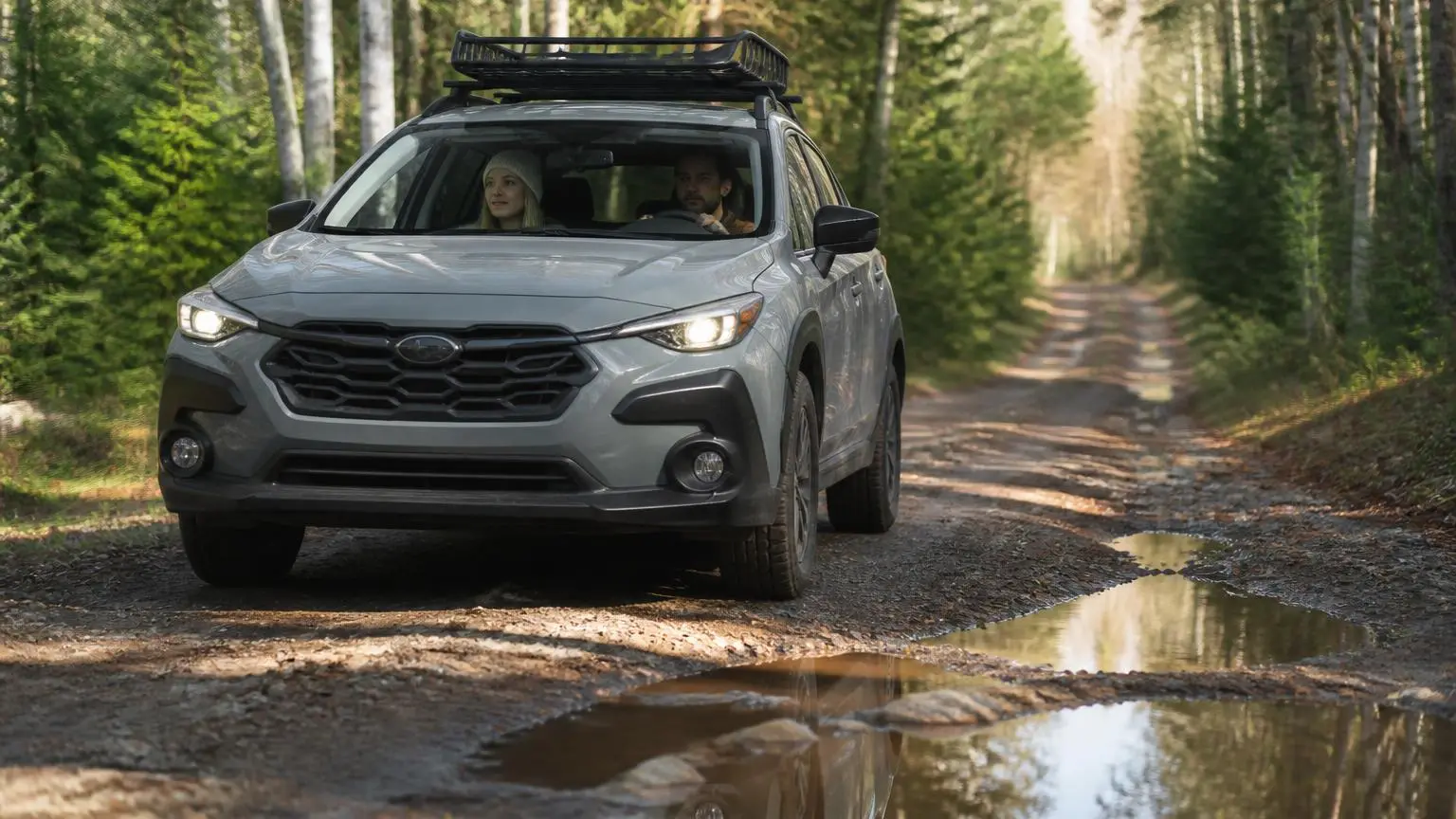 Compact crossover with all-terrain tires on a forest dirt road