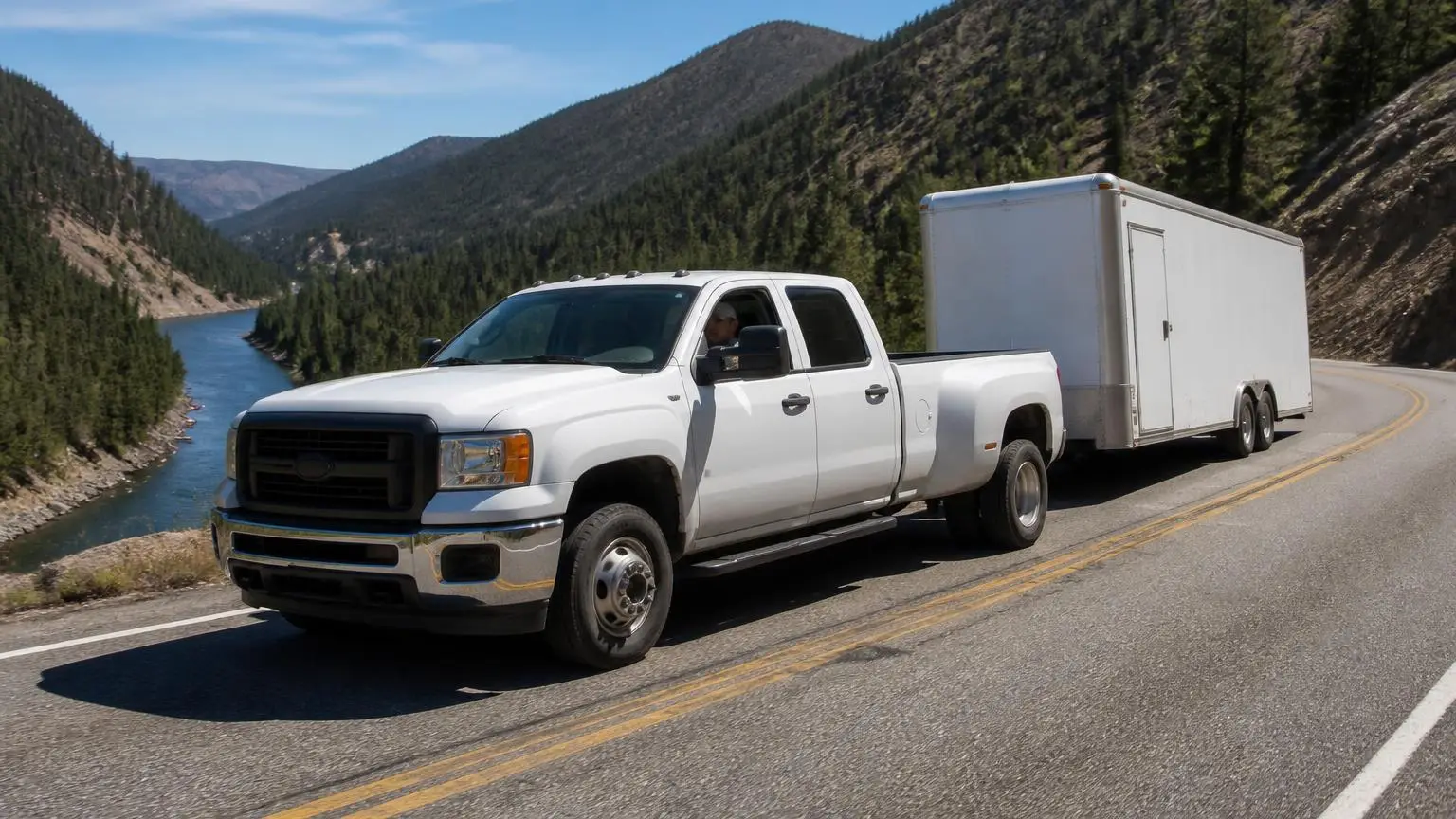 Heavy-duty diesel pickup towing a big trailer through mountains