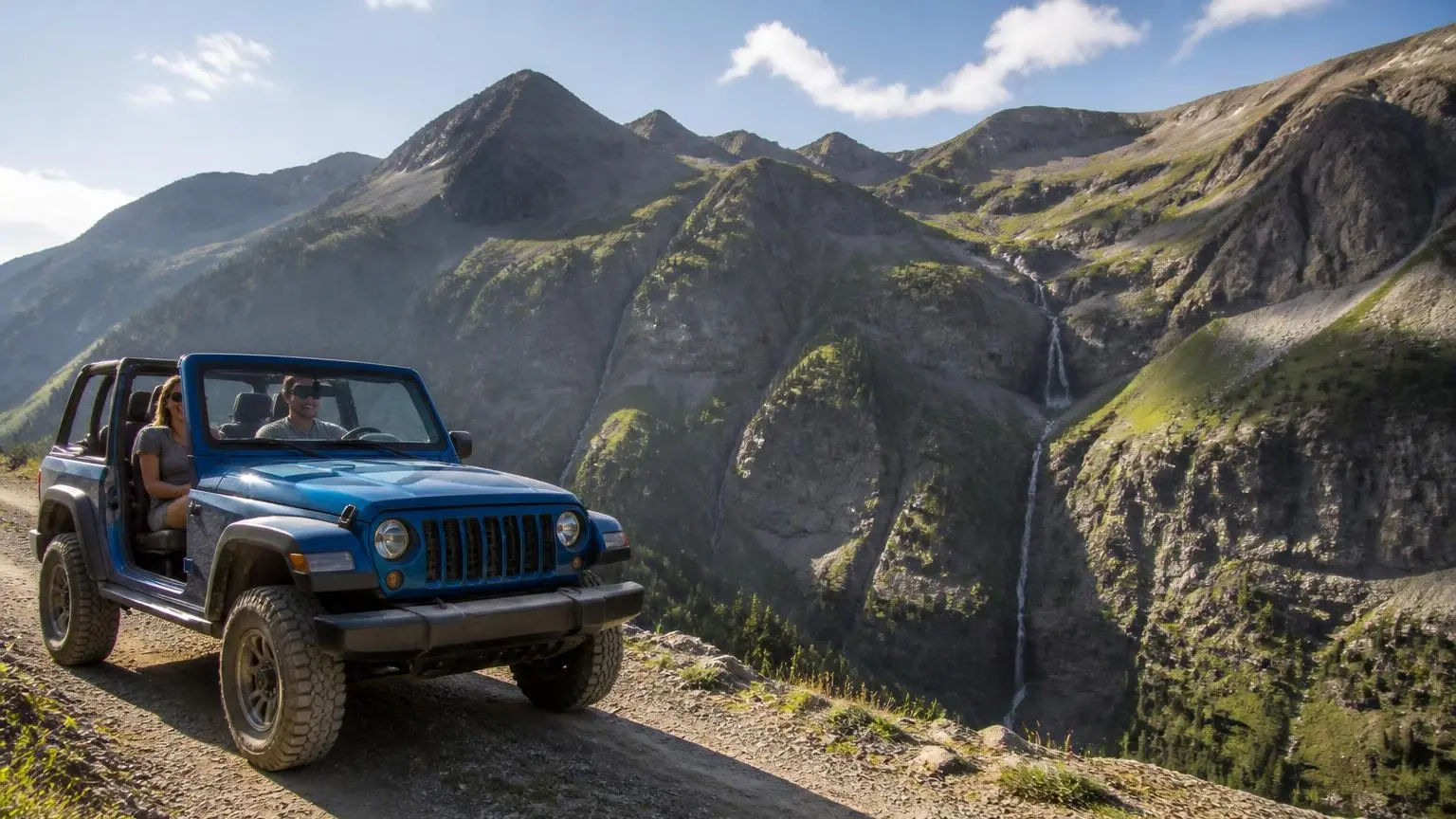 Two-door off-roader with doors off on a mountain shelf road