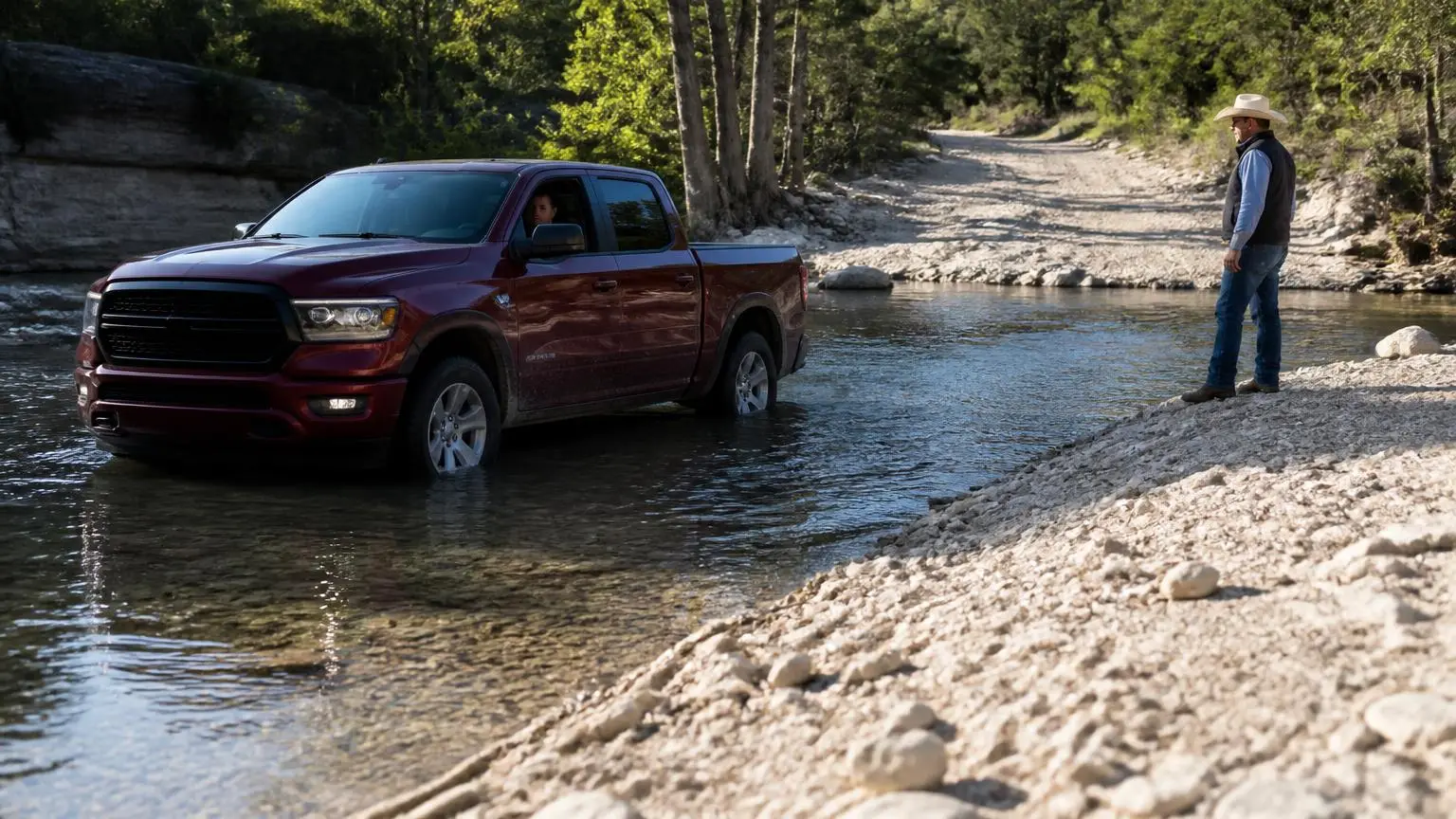 Full-size pickup driving through a Texas hill country creek crossing