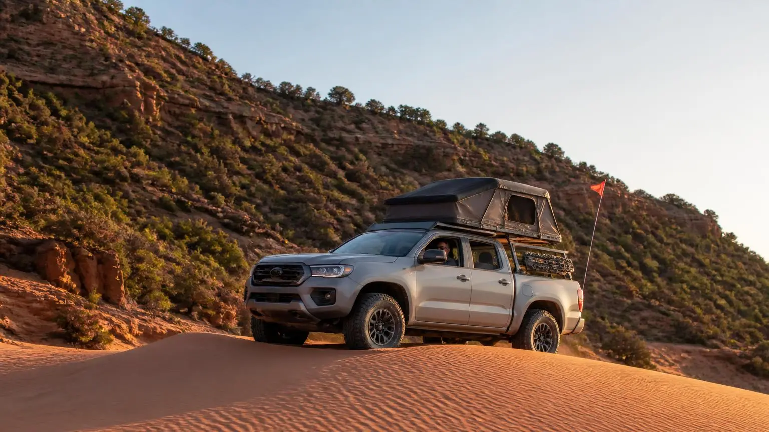 Illustrative: a 4WD cresting a pink sand dune in southern Utah