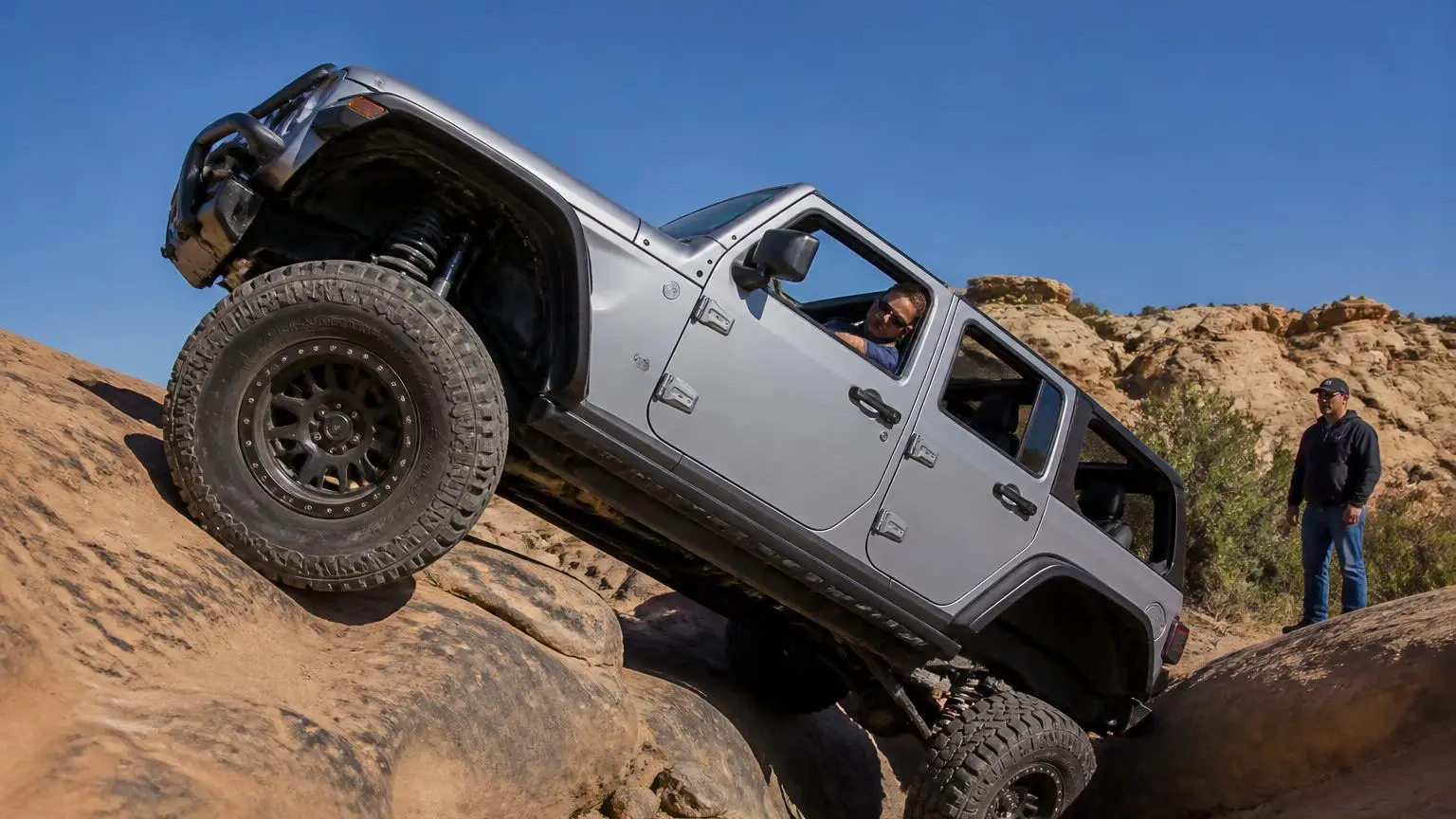A 4WD flexing its suspension over a rocky obstacle