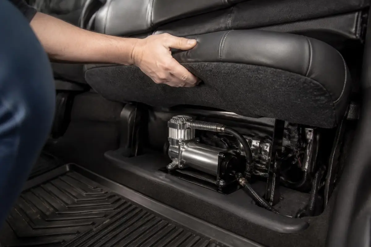 Mounted compressor under a rear seat
