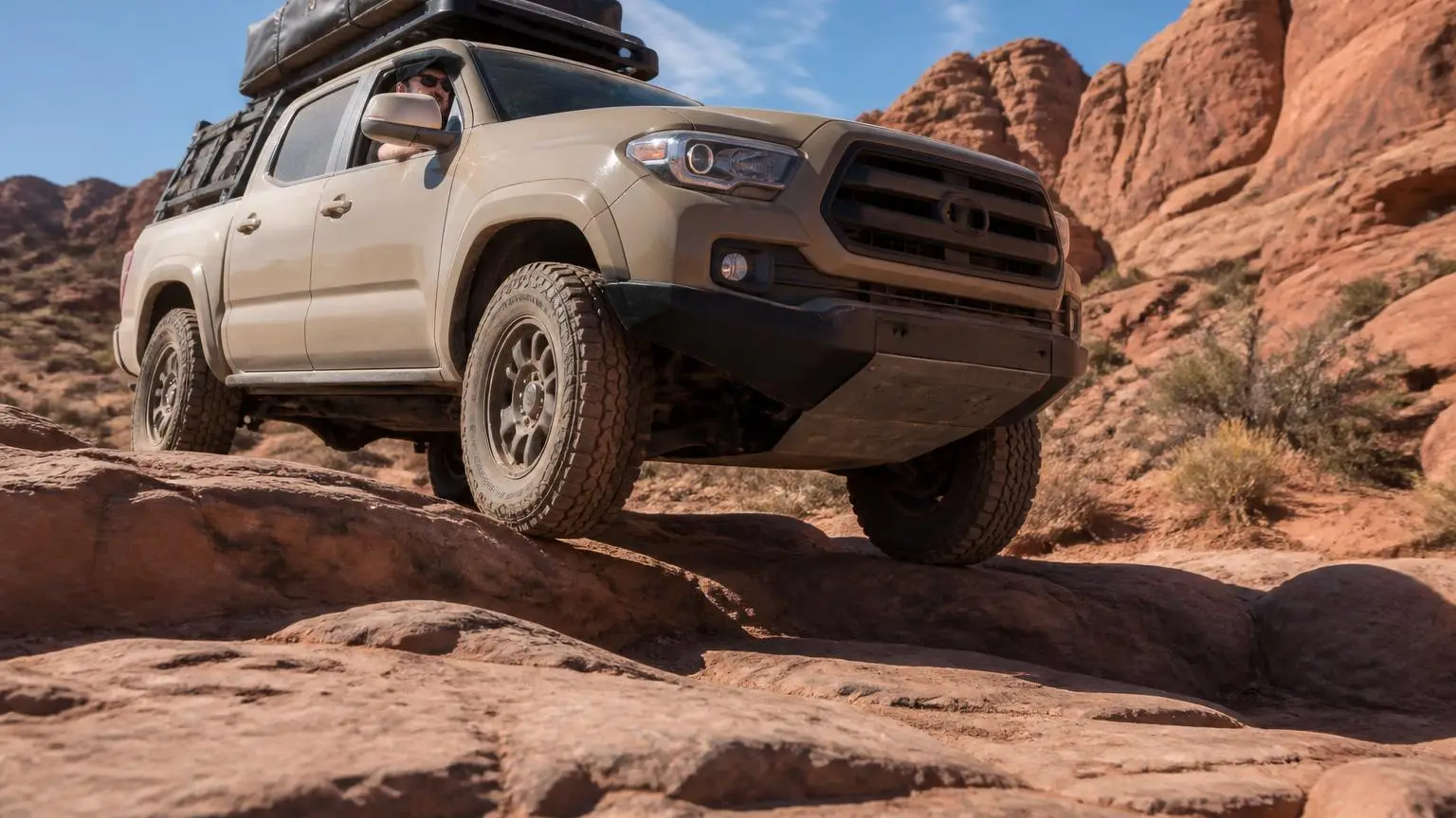 Truck scraping its skid plate over a rock ledge
