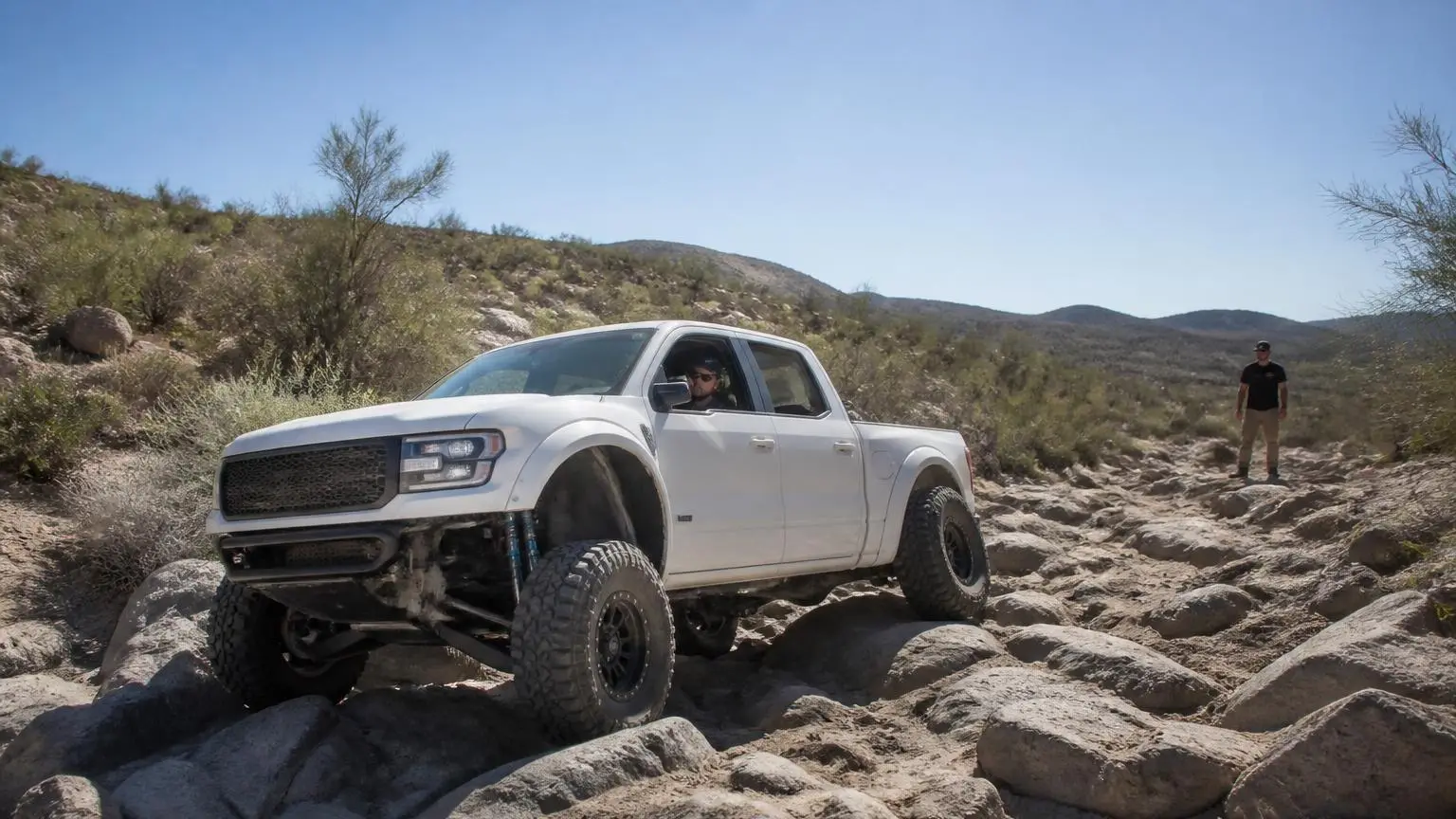 Full-size pickup with long-travel suspension on a desert trail