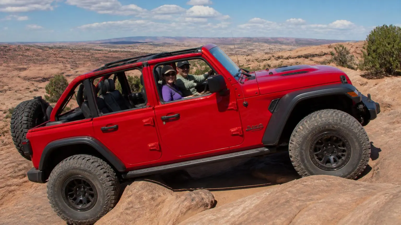 Four-door off-roader with removable roof on a slickrock trail