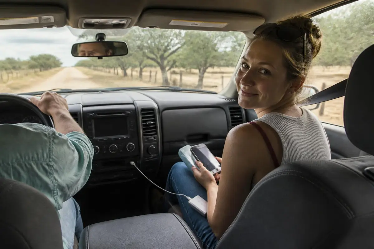 Passenger with a phone map and battery pack inside a moving truck