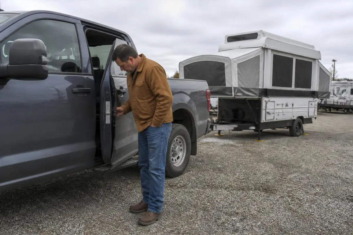 Man checking the payload sticker on a pickup door jamb
