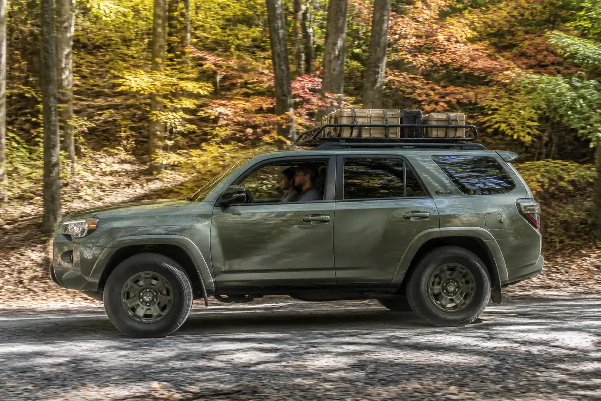 Loaded overland SUV driving a forest road