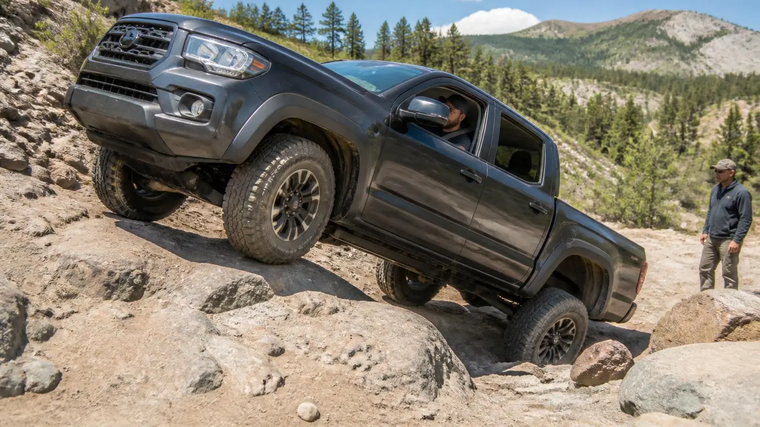 Lifted pickup flexing on a rocky trail
