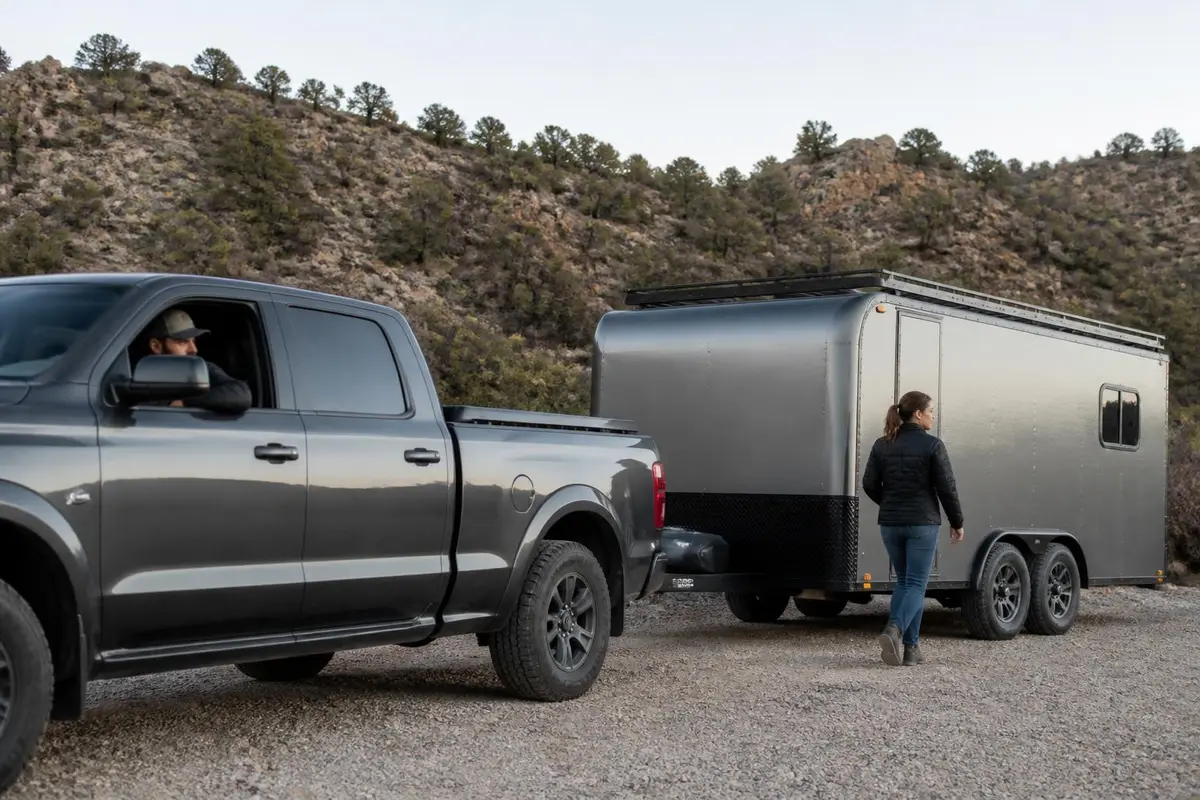 Owner walking back to check trailer visibility behind a pickup