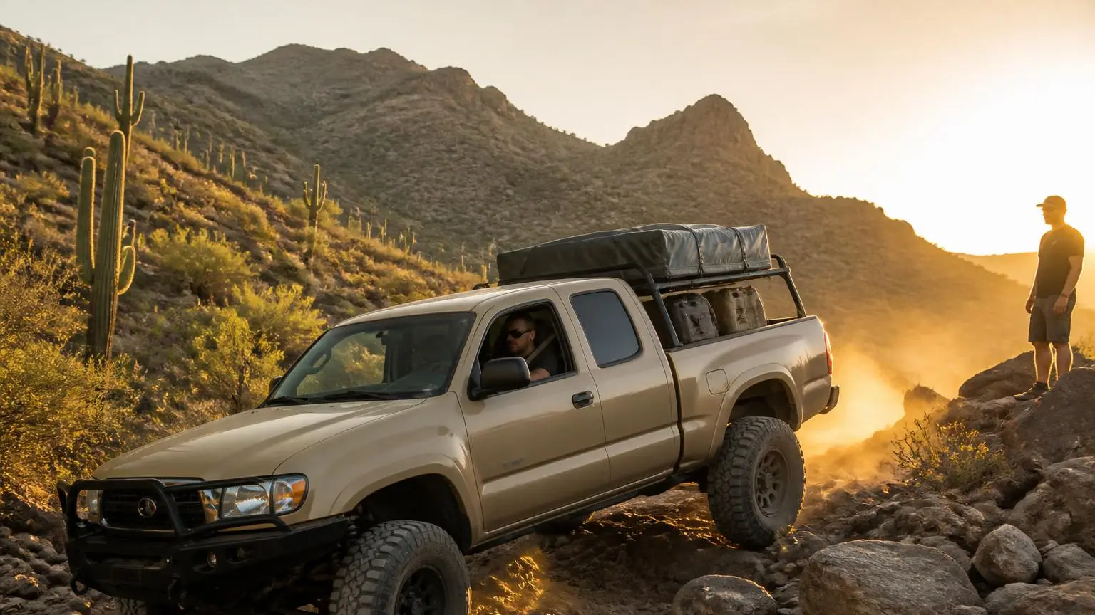 Mid-size pickup climbing a rocky desert trail at golden hour