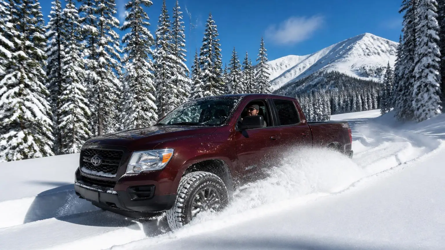 Pickup on snow-rated all-terrain tires on a snowy forest road