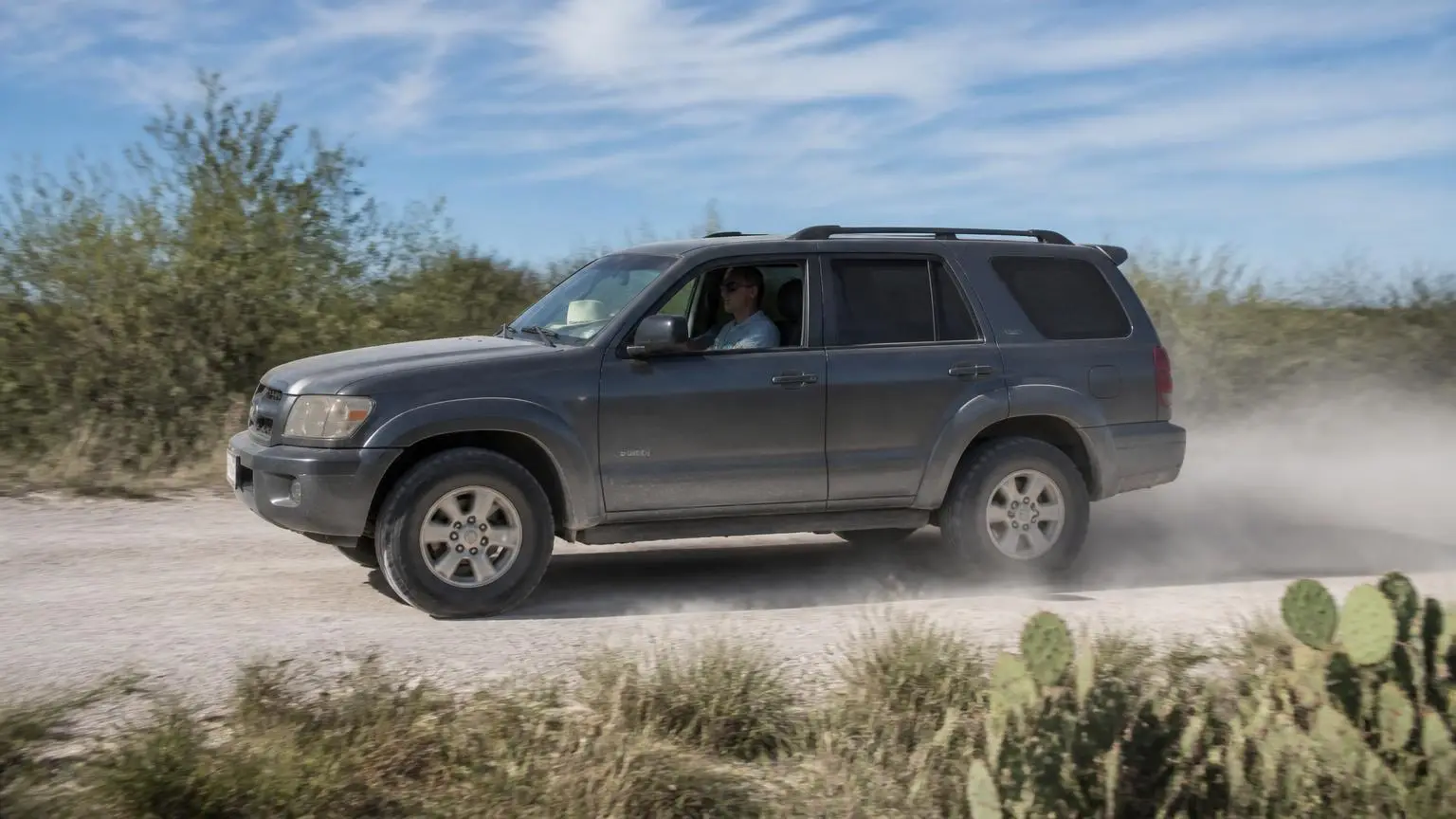 Mid-size SUV on all-terrain tires on a white caliche road