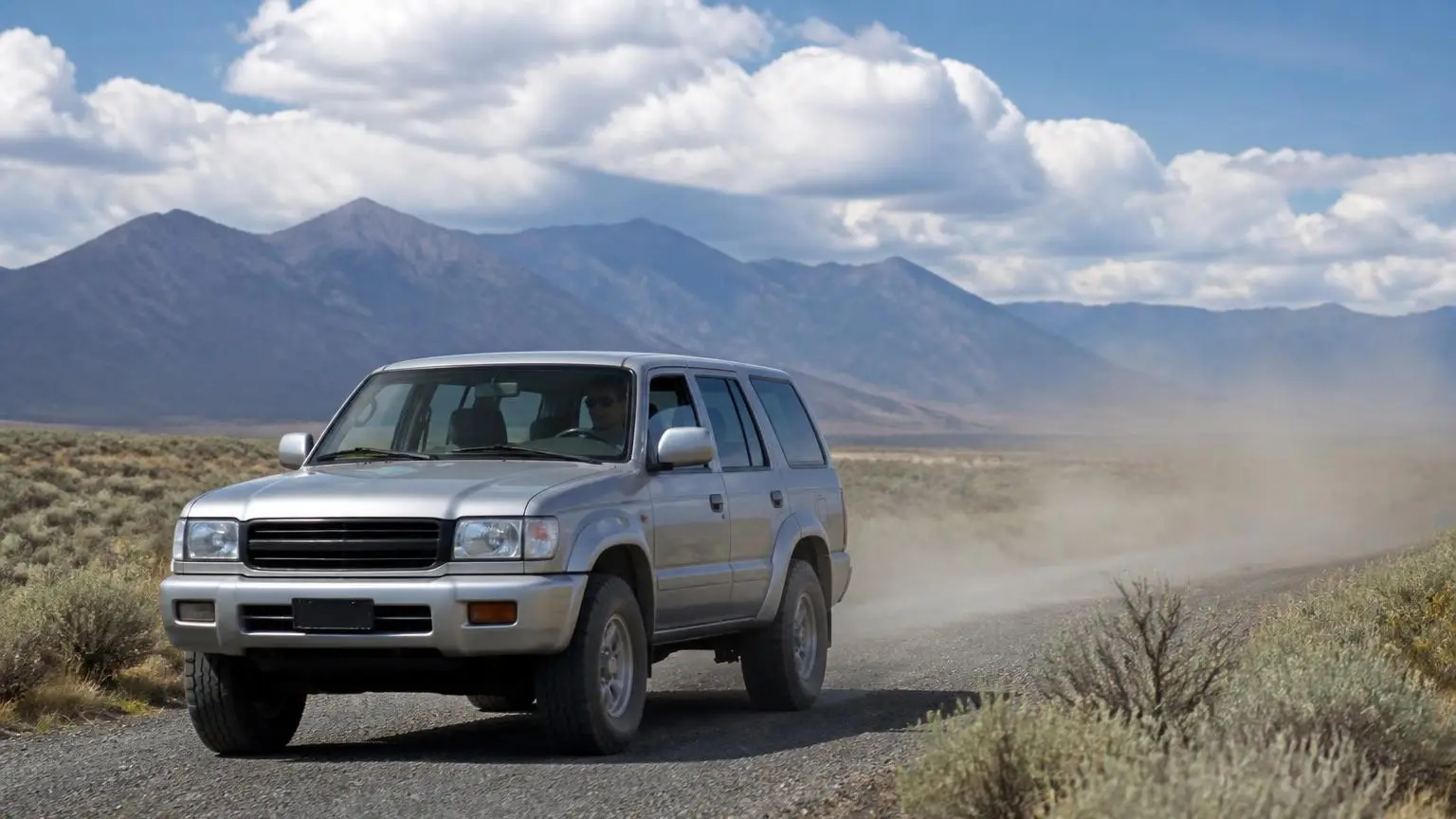 Mid-size SUV on all-terrain tires on a gravel road through sagebrush