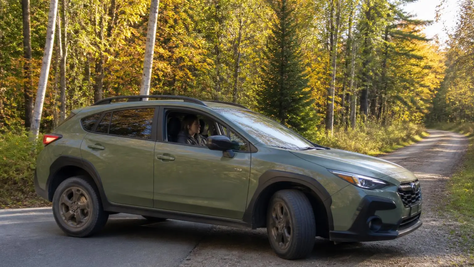 Crossover on light all-terrain tires turning onto a forest road